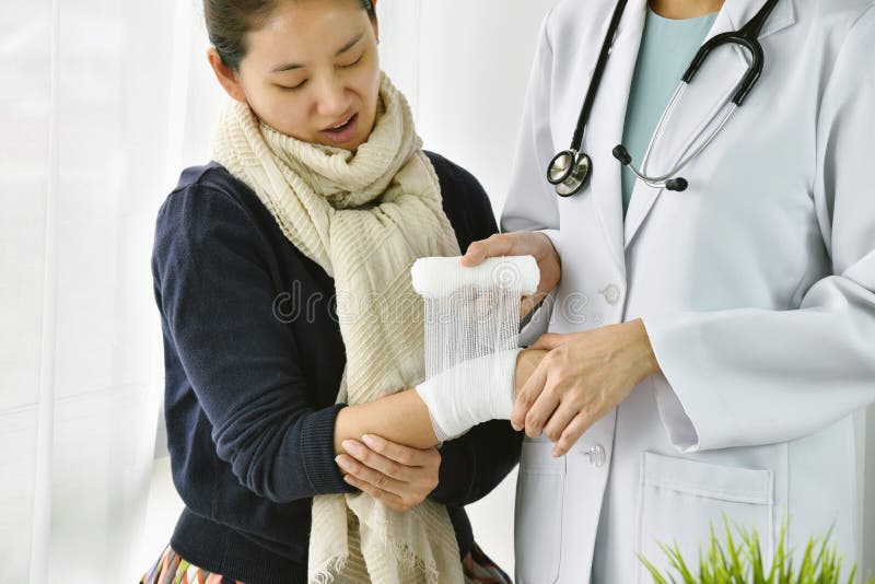 Accident Injury hand, Asian female doctor with stethoscope bandaging hand of patient in hospital. royalty free stock images Accident Injury hand, Asian female doctor with stethoscope bandaging hand of patient in hospital. royalty free stock images