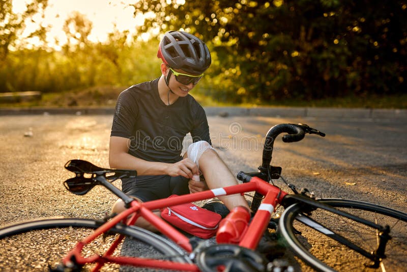 Atleta ciclista caucásico en ropa de ciclismo y casco con bicicleta mirando  a la cámara hombre descansando y relajándose después del entrenamiento en  bicicleta en las calles del parque natural estilo de