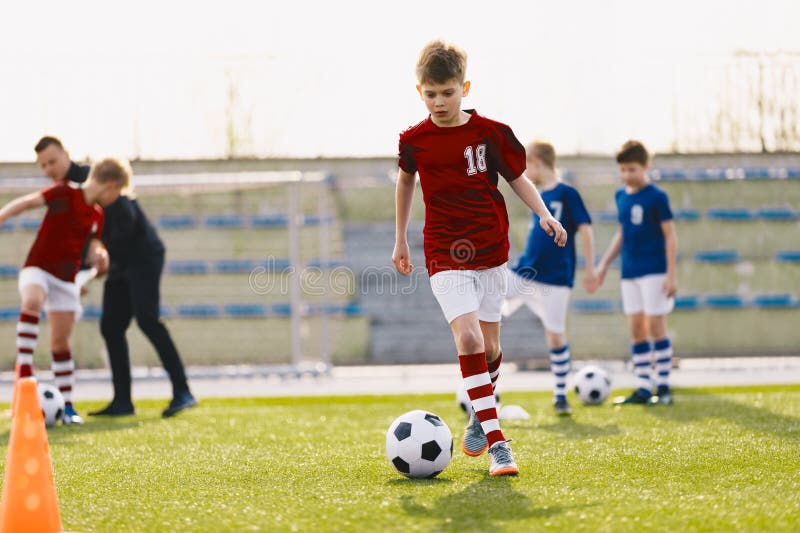 Acción de entrenamiento de los equipos de fútbol masculino de 1012 jugando en el campo de prácticas de fútbol imágenes de archivo libres de regalías