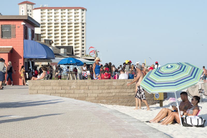 Accoppi la seduta sotto un ombrello su un sentiero costiero della spiaggia fotografia stock libera da diritti Accoppi la seduta sotto un ombrello su un sentiero costiero della spiaggia fotografia stock libera da diritti