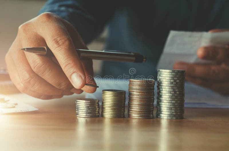 Accountin di affari con i soldi di risparmio con la mano che mette le monete sopra immagini stock Accountin di affari con i soldi di risparmio con la mano che mette le monete sopra immagini stock