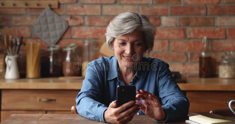 Accro à la technologie moderne heureux femme plus âgée utilisant le téléphone cellulaire. banque de vidéos