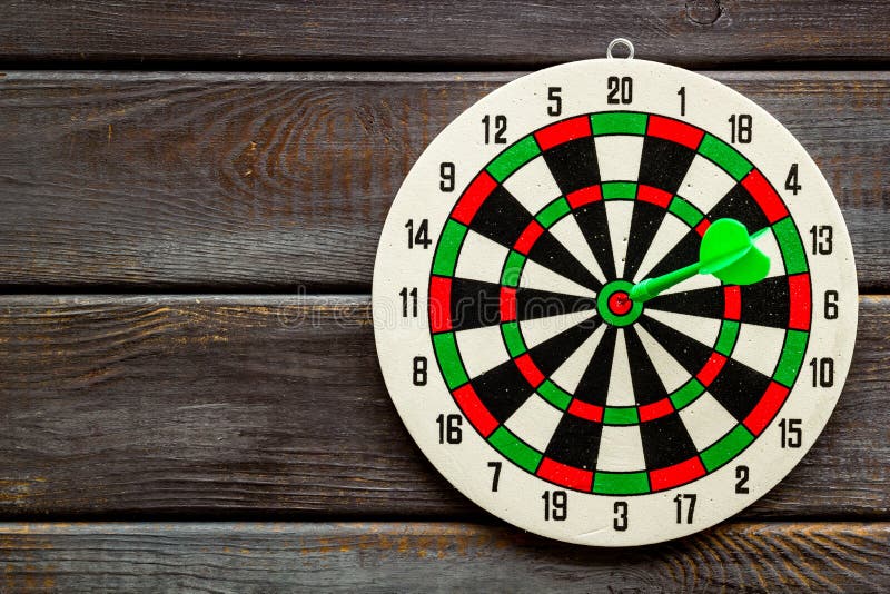 Accuracy of Precision Concept. Dartboard and Arrows on Dark Wooden