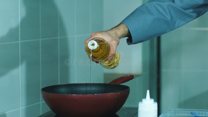 Aceite de colada del cocinero adentro al sartén para cocinar metrajes
