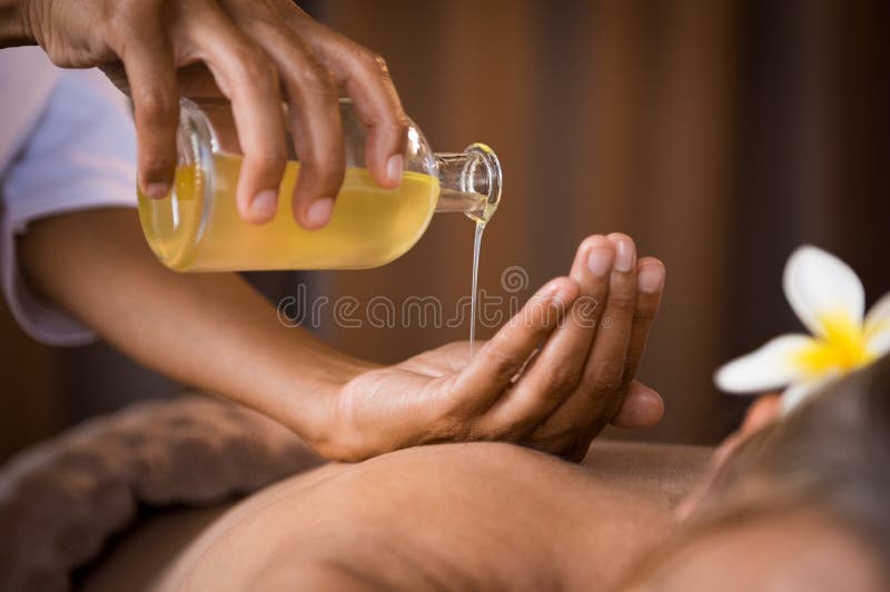 Aceite de colada del masaje del terapeuta en el balneario