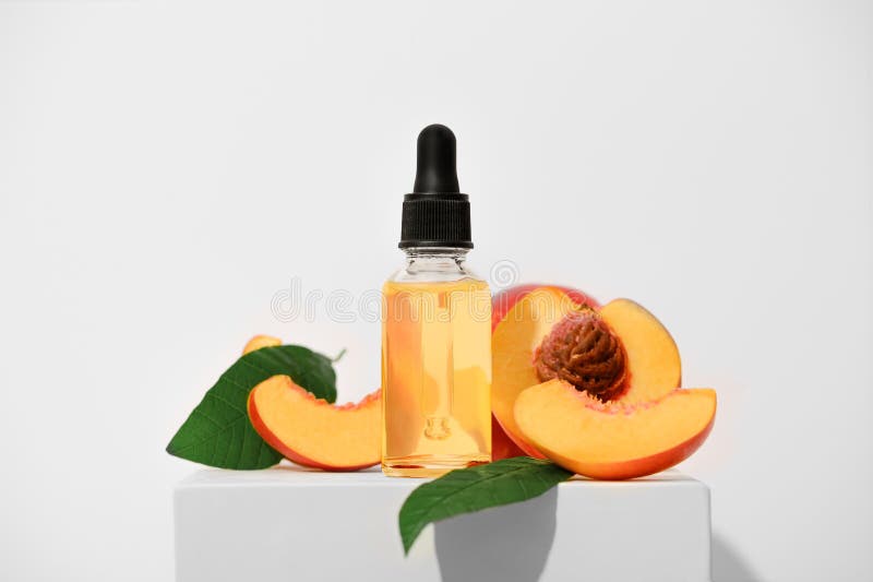 Aceite esencial de melocotón aromático sobre un soporte blanco. un aceite aromático de spa de frutas para el cuidado de la piel. p