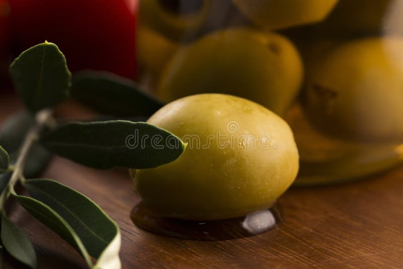 Aceitunas y rama de olivo conservadas en vinagre foto de archivo Aceitunas y rama de olivo conservadas en vinagre foto de archivo