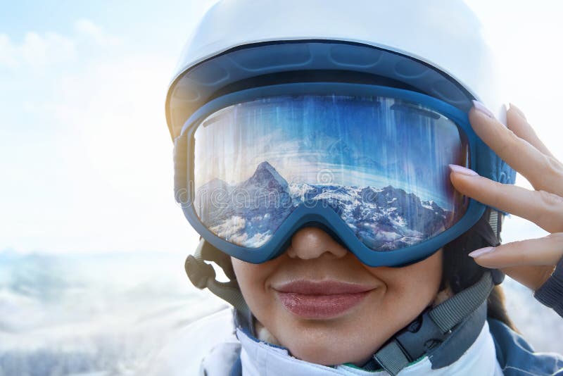 Gafas de esquí con el reflejo de las montañas nevadas. hombre en el cielo  azul de fondo. deportes de invierno.