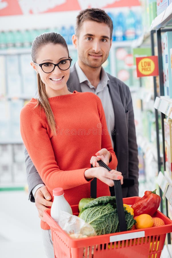 Achats heureux de couples au magasin image libre de droits Achats heureux de couples au magasin image libre de droits