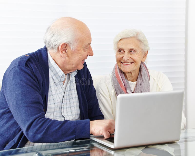 Couple de seniors faisant des achats sur internet images stock