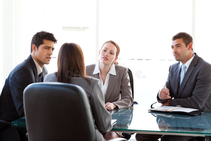 Rear view of a businesswoman being interviewed by three executives sitting around a table. Rear view of a businesswoman being interviewed by three executives sitting around a table