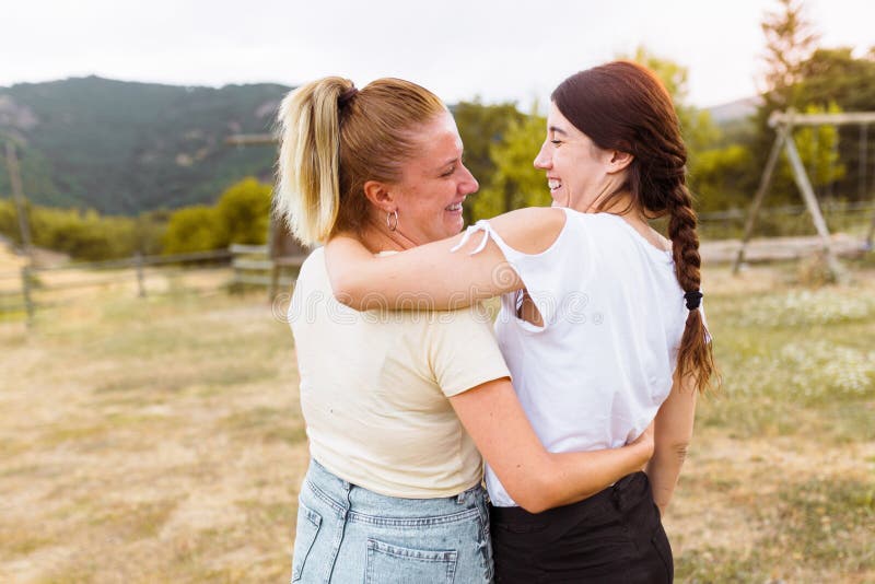 Achteraanzicht van vriendinnen glimlachen en omhelzen elkaar op het platteland Beste vriend, liefde en vriendschapsconcept stock foto's Achteraanzicht van vriendinnen glimlachen en omhelzen elkaar op het platteland Beste vriend, liefde en vriendschapsconcept stock foto's