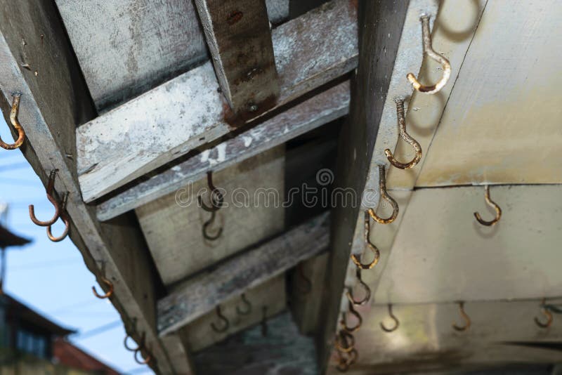 Achtergrondoppervlakte van oude en roestige haken die op het dak van winkel hangen stock foto's Achtergrondoppervlakte van oude en roestige haken die op het dak van winkel hangen stock foto's