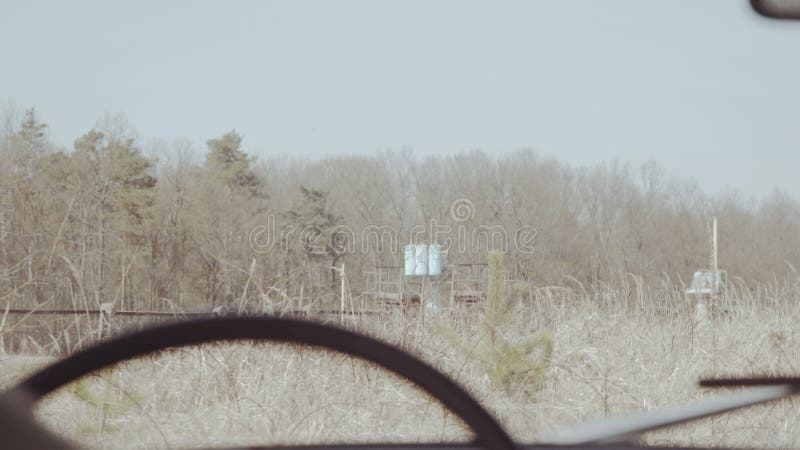 Achterhoek schuddende mening van het oude mens drijven in de retro auto bij niet stedelijke weg