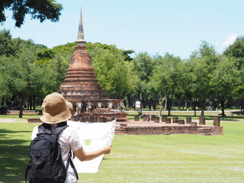 Achtermening van Aziatische vrouw die backpacker de kaart bij oude te bekijken royalty-vrije stock foto's Achtermening van Aziatische vrouw die backpacker de kaart bij oude te bekijken royalty-vrije stock foto's