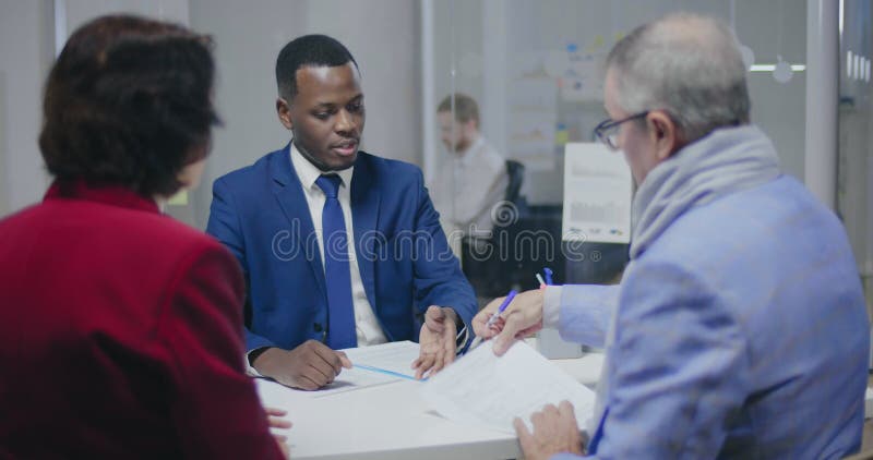 Achterkant van een oudere man die documenten ondertekent stock videobeelden