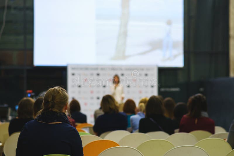 Achtermening van de deelnemers van het seminarie, de opleiding of de lezing in een groot publiek met het groot scherm stock foto's Achtermening van de deelnemers van het seminarie, de opleiding of de lezing in een groot publiek met het groot scherm stock foto's