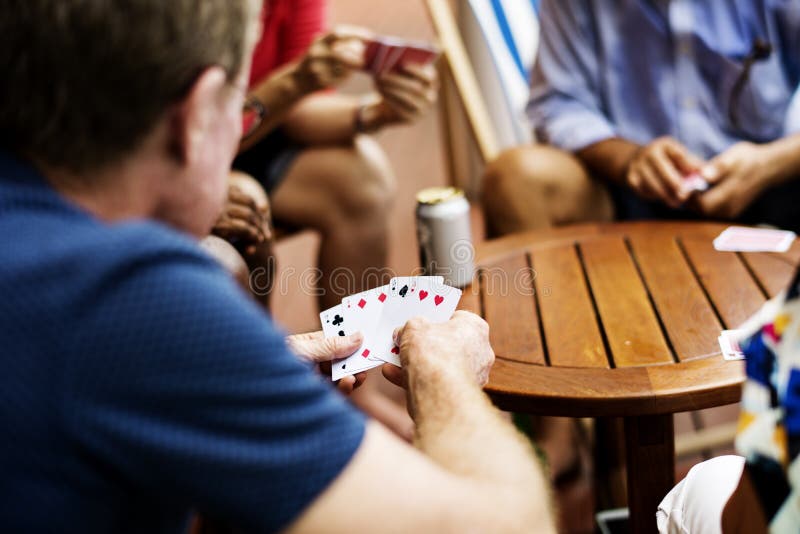 Achtermening van het spel van de mensenspeelkaart met vrienden stock afbeeldingen Achtermening van het spel van de mensenspeelkaart met vrienden stock afbeeldingen