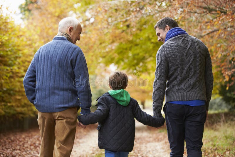Achtermening van Mannelijke Multl-Generatiefamilie die op Weg lopen stock afbeeldingen Achtermening van Mannelijke Multl-Generatiefamilie die op Weg lopen stock afbeeldingen