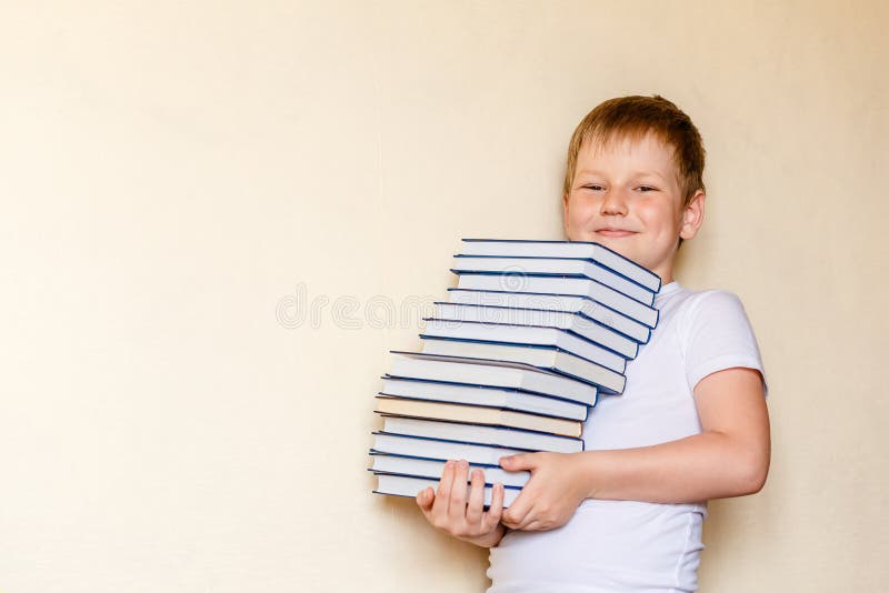 Achtjähriger lächelnder Junge, der viele Bücher hält Erst-Sortierer stockfoto Achtjähriger lächelnder Junge, der viele Bücher hält Erst-Sortierer stockfoto