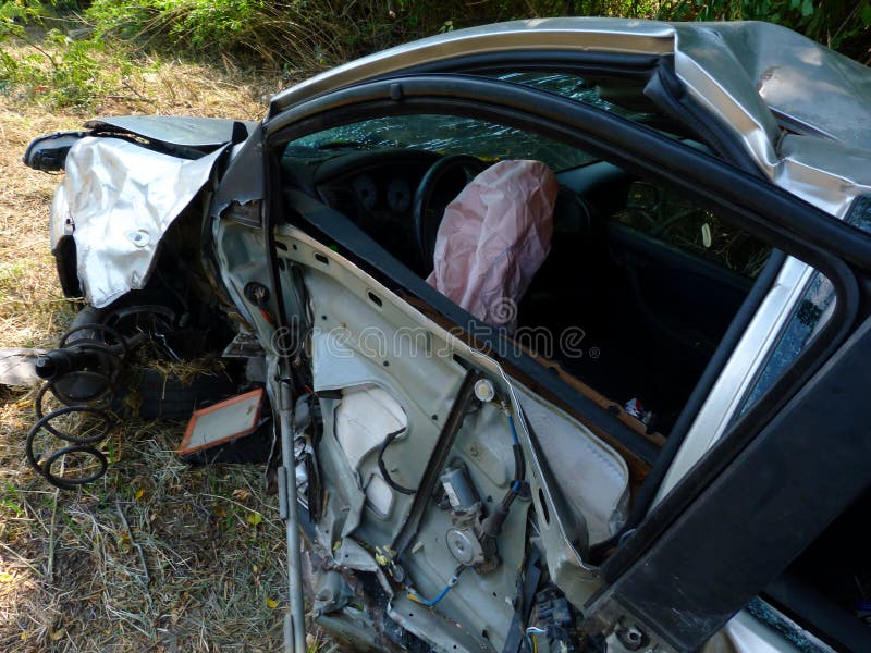 Crashed car wreck left on road side after serious road collision. spent pink air bag displayed sticking out of steering wheel. broken glass wind shield. total write off for insurance purposes. serious car accident . Crashed car wreck left on road side after serious road collision. spent pink air bag displayed sticking out of steering wheel. broken glass wind shield. total write off for insurance purposes. serious car accident