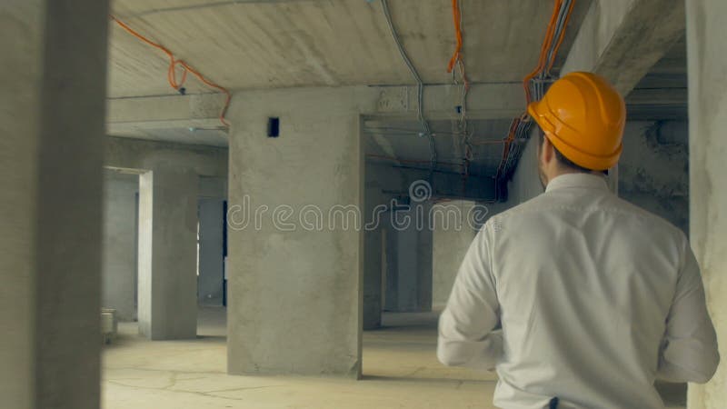 Acionista que inspeciona a construção Homem de negócios no capacete de segurança dentro do progresso de exame da construção do ca video estoque Acionista que inspeciona a construção Homem de negócios no capacete de segurança dentro do progresso de exame da construção do ca video estoque