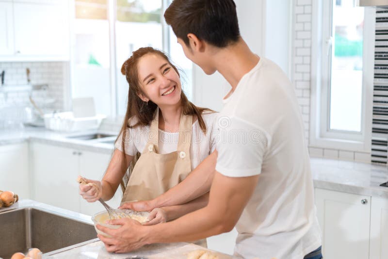Acople o cozimento da padaria na sala da cozinha, no homem asiático novo e na mulher junto fotos de stock Acople o cozimento da padaria na sala da cozinha, no homem asiático novo e na mulher junto fotos de stock