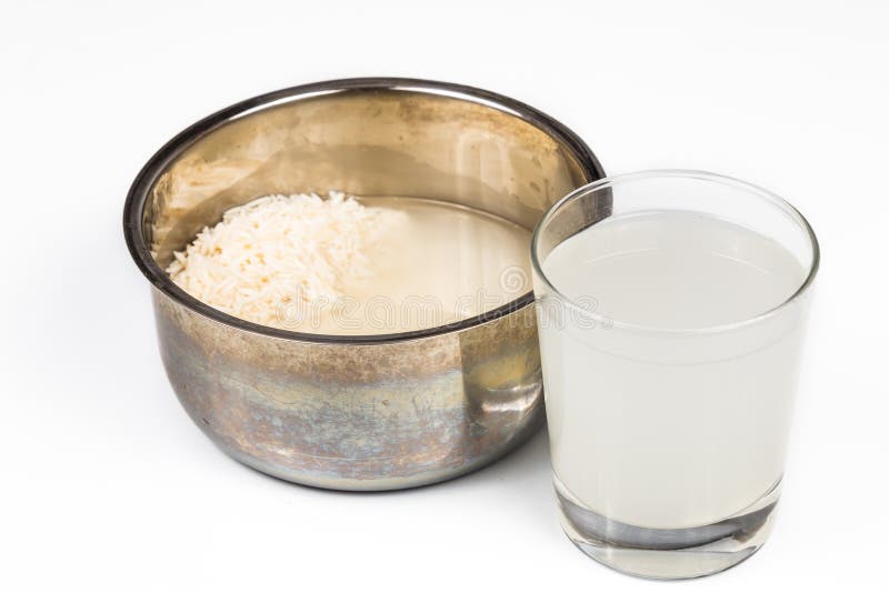Acqua dal risciacquo del riso che è usando come fertilizzante naturale sulla pianta in vaso