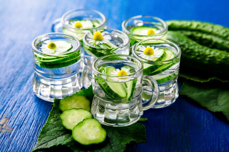 Acqua del cetriolo in sei barattoli di vetro del piccolo muratore su fondo blu rustic detox immagine stock libera da diritti Acqua del cetriolo in sei barattoli di vetro del piccolo muratore su fondo blu rustic detox immagine stock libera da diritti