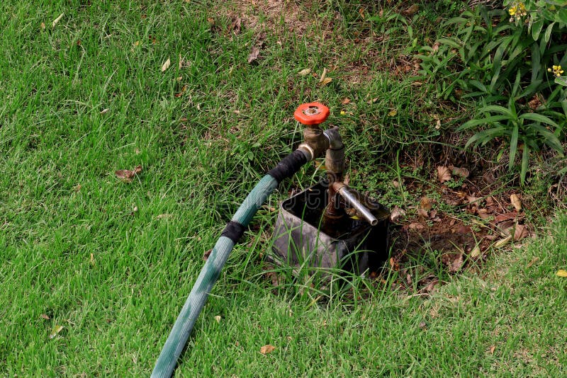 Acqua del rubinetto dalla valvola dell'acqua del rubinetto, valvola a saracinesca nel giardino verde immagini stock libere da diritti Acqua del rubinetto dalla valvola dell'acqua del rubinetto, valvola a saracinesca nel giardino verde immagini stock libere da diritti