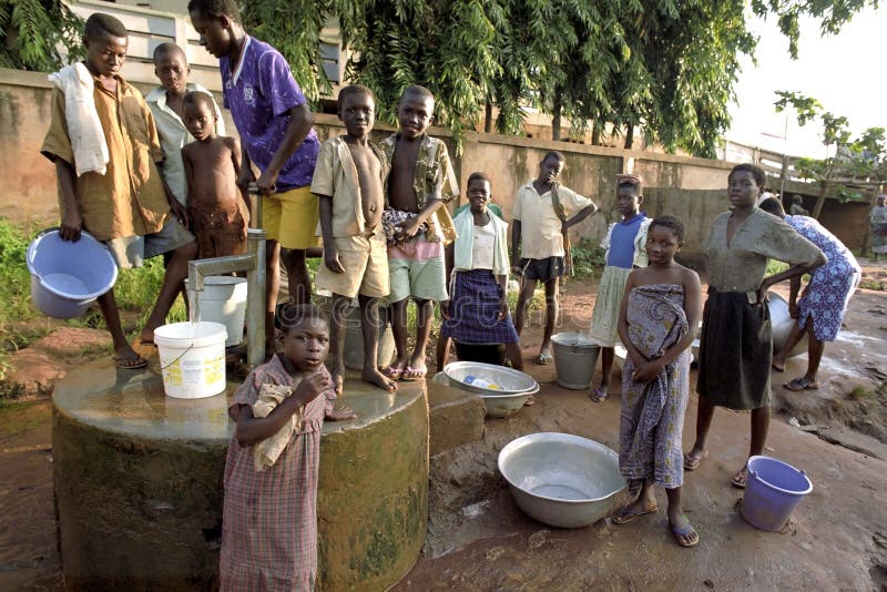 Acqua di ampiezza dei giovani ad una pompa idraulica fotografia stock libera da diritti Acqua di ampiezza dei giovani ad una pompa idraulica fotografia stock libera da diritti