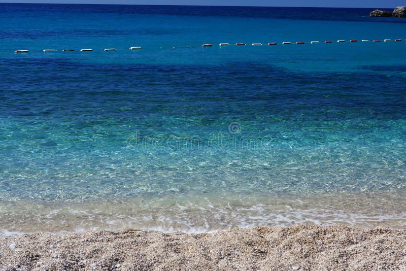 Acqua di mare pulita trasparente fuori dalla costa, una pendenza del blu dalla spiaggia alla profondità, recinti della boa fotografie stock