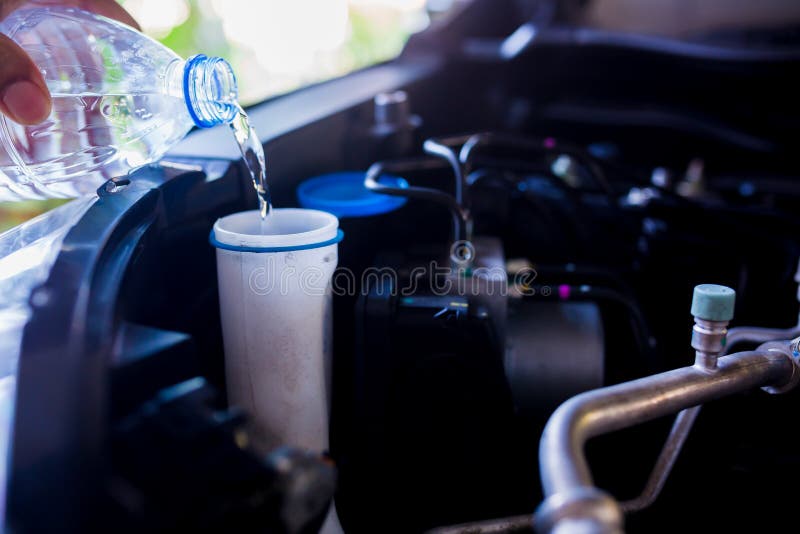 Acqua dolce del materiale di riempimento del meccanico nel tergicristallo o in tergicristallo del serbatoio di acqua fotografia stock Acqua dolce del materiale di riempimento del meccanico nel tergicristallo o in tergicristallo del serbatoio di acqua fotografia stock