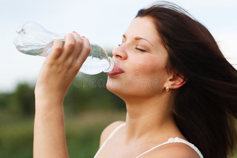 Acqua potabile della bella donna immagini stock libere da diritti Acqua potabile della bella donna immagini stock libere da diritti