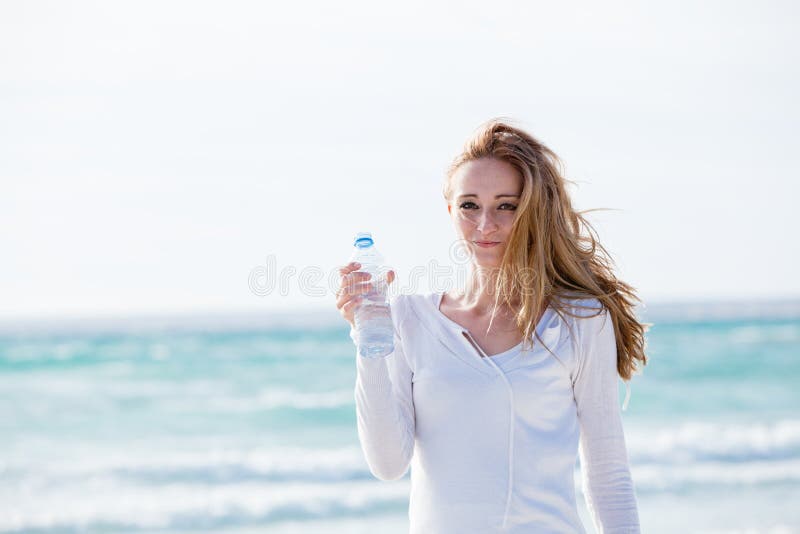Acqua potabile della bella giovane donna di estate immagine stock libera da diritti Acqua potabile della bella giovane donna di estate immagine stock libera da diritti