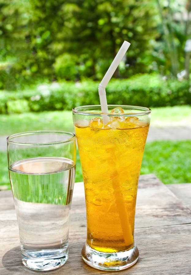 Acqua potabile e tè ghiacciato del crisantemo. Un vetro di acqua potabile e del tè ghiacciato del crisantemo (tè del fiore) sulla tabella di legno