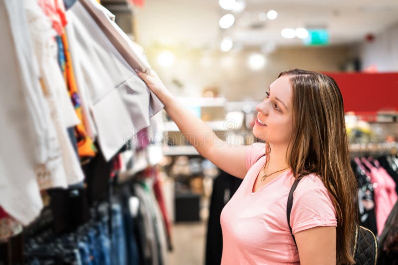Acquisto della giovane donna nel negozio di vestiti immagini stock Acquisto della giovane donna nel negozio di vestiti immagini stock