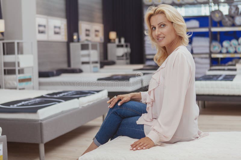 Acquisto maturo elegante splendido della donna per il letto ortopedico nuovo immagini stock libere da diritti Acquisto maturo elegante splendido della donna per il letto ortopedico nuovo immagini stock libere da diritti