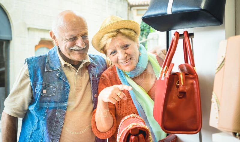 Acquisto senior felice delle coppie al deposito della borsa di modo immagine stock libera da diritti Acquisto senior felice delle coppie al deposito della borsa di modo immagine stock libera da diritti