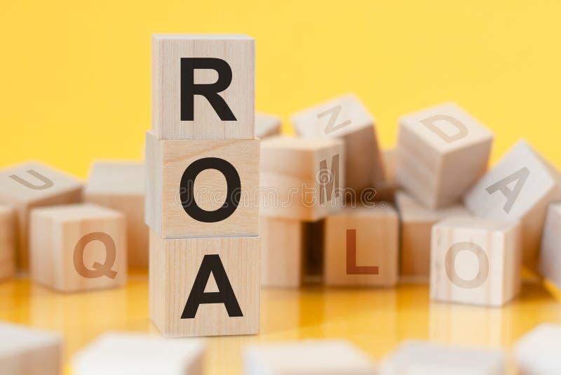 Wooden cubes with letters roa arranged in a vertical pyramid, yellow background, reflection from the surface of the table, business concept, roa - short for return on assets. Letters roa stock images, royalty-free photos and pictures