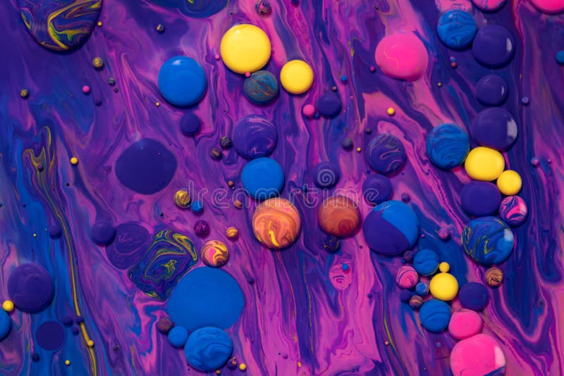 Acrylic paint balls abstract texture. Purple, blue and yellow liquids mix. Creative multicolor background. Bright colors