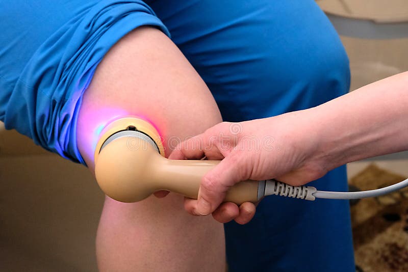 Actes m?dicaux pour les personnes ?g?es Le docteur chauffe le genou de la femme avec un appareil microcurrent sp?cial Traitement photo stock Actes m?dicaux pour les personnes ?g?es Le docteur chauffe le genou de la femme avec un appareil microcurrent sp?cial Traitement photo stock