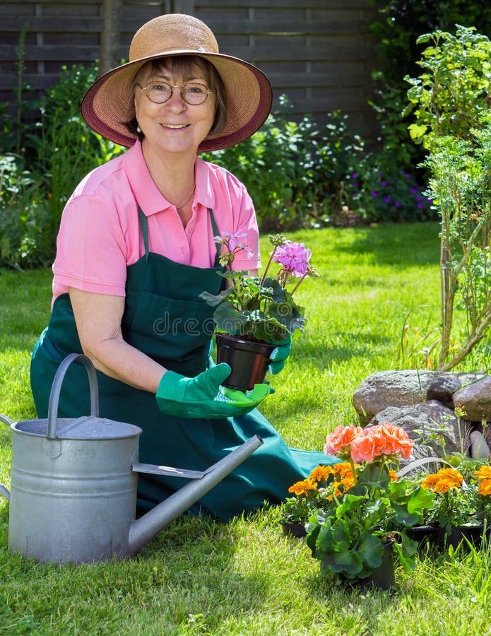 Actieve hogere vrouwen die in haar tuin werken