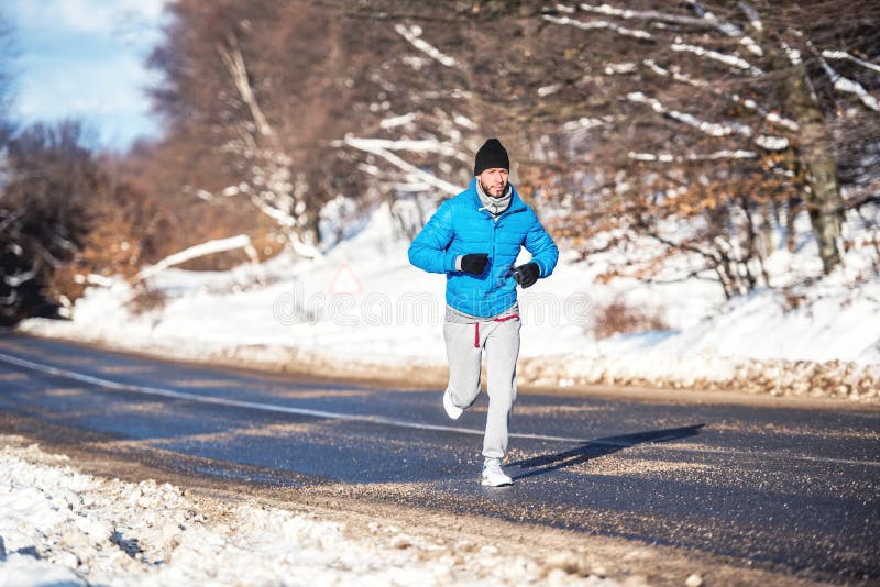 Actieve mens, jogging en het lopen tijdens een zonnige de winterdag Het openlucht uitwerken stock afbeeldingen Actieve mens, jogging en het lopen tijdens een zonnige de winterdag Het openlucht uitwerken stock afbeeldingen