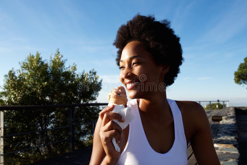 Actieve vrouw die etend roomijs bij het strand genieten van royalty-vrije stock afbeeldingen Actieve vrouw die etend roomijs bij het strand genieten van royalty-vrije stock afbeeldingen