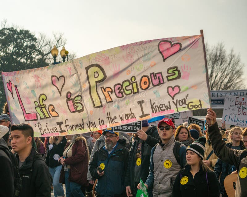 WASHINGTON D.C./USA - JANUARY 18, 2019: Pro-life supporters holding a banner wlak in annual March for Life. WASHINGTON D.C./USA - JANUARY 18, 2019: Pro-life supporters holding a banner wlak in annual March for Life