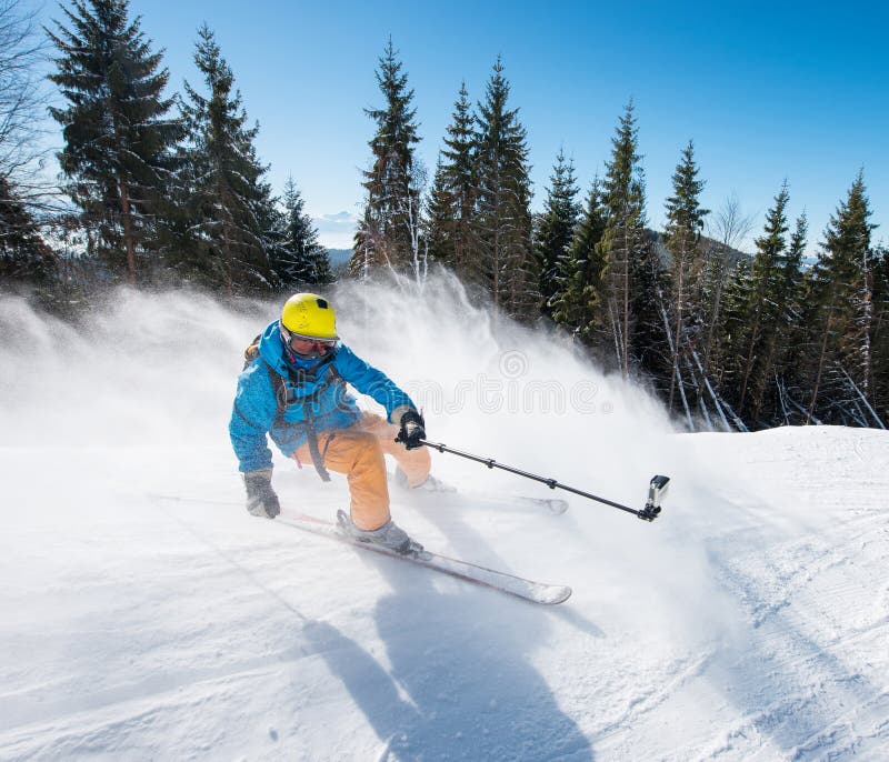 Action shot of professional skier taking selfies photo with a camera on selfie stick while skiing stock photos Action shot of professional skier taking selfies photo with a camera on selfie stick while skiing stock photos