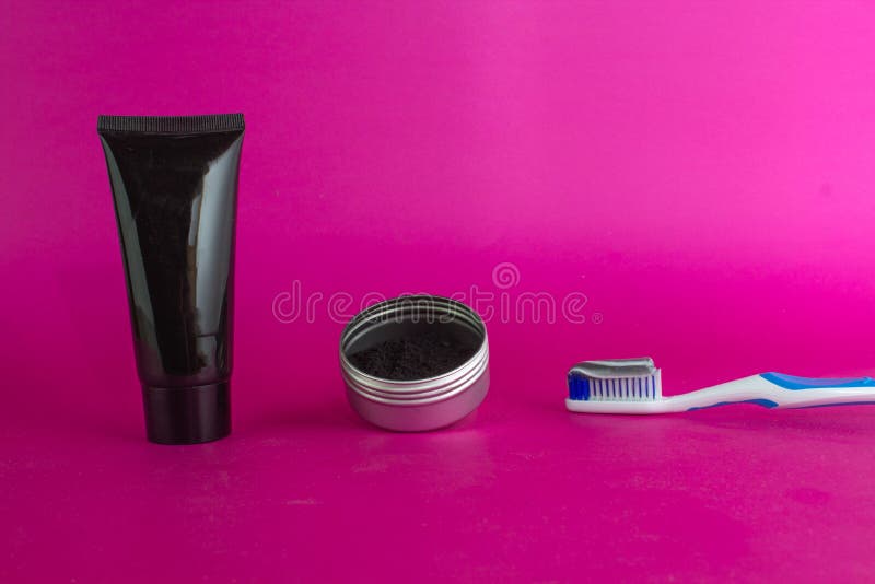 Activated charcoal in container next to toothbrush with toothpaste. and face mask royalty free stock image