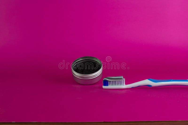Activated charcoal in container next to toothbrush with toothpaste. personal care concept