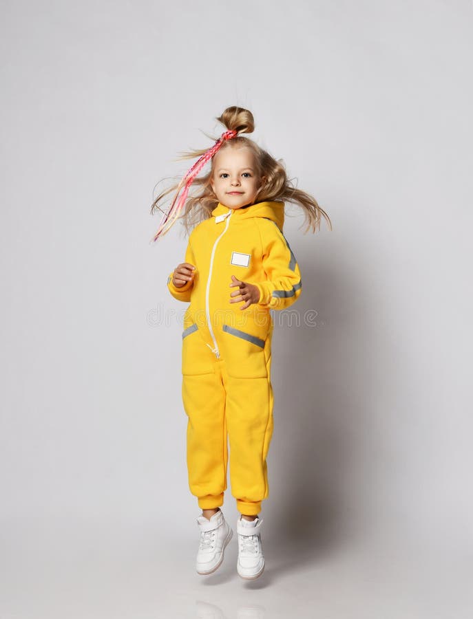 Active Blonde Kid Baby Girl with Modern Hairstyle and Colorful Braids  Wearing Stylish Yellow Jumpsuit and Sneakers Jumps Stock Image - Image of  cool, jumpsuit: 198479703